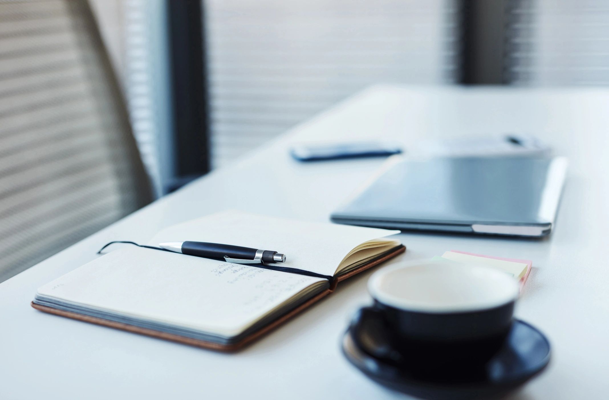 Notebook and laptop on a desk in a professional office