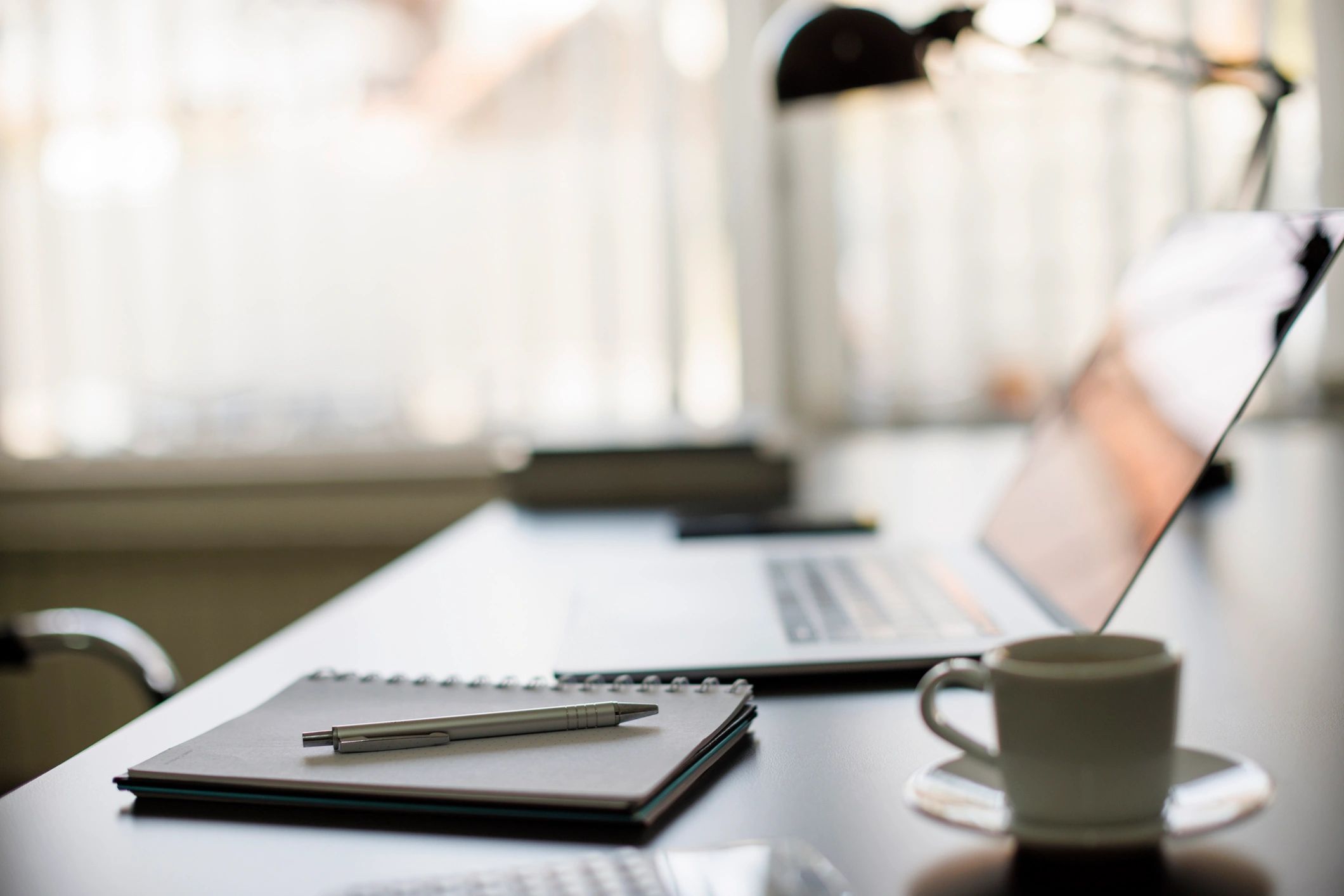 Desk with laptop and notebook used for website planning